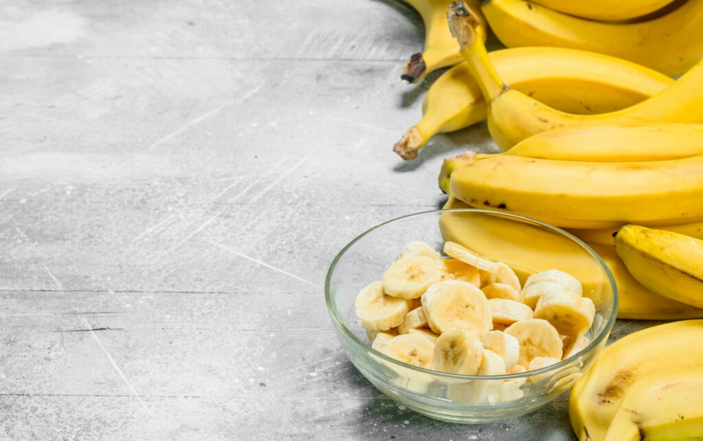 Bananas and banana slices in a glass plate.