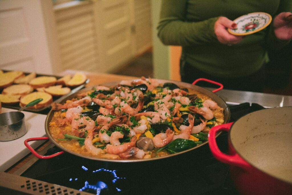 Cooking paella with seafood over stovetop