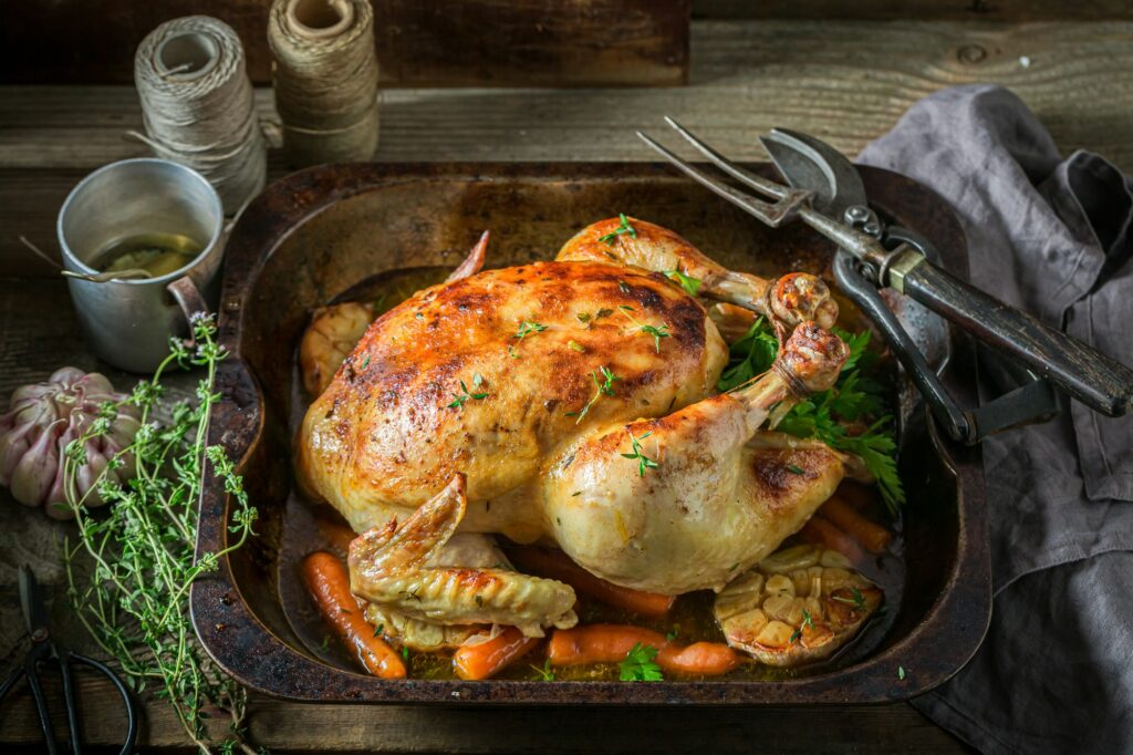 Grilled chicken with thyme and carrots. Roasted chicken with herbs.