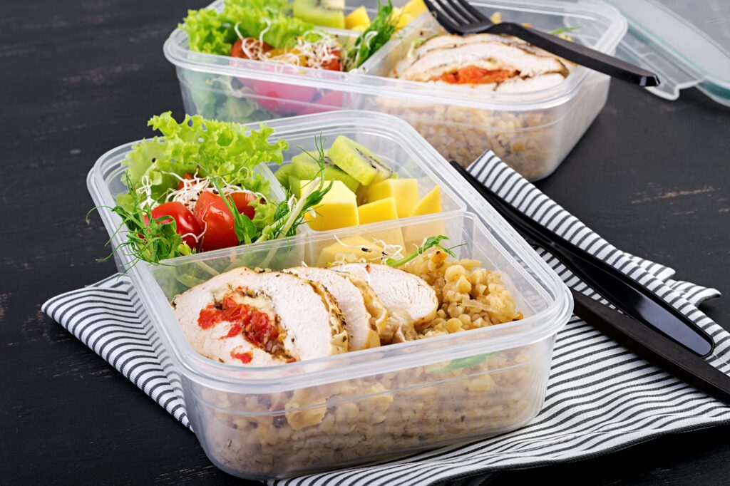 Lunch box chicken, bulgur, microgreens, tomato and fruit. Healthy fitness food.