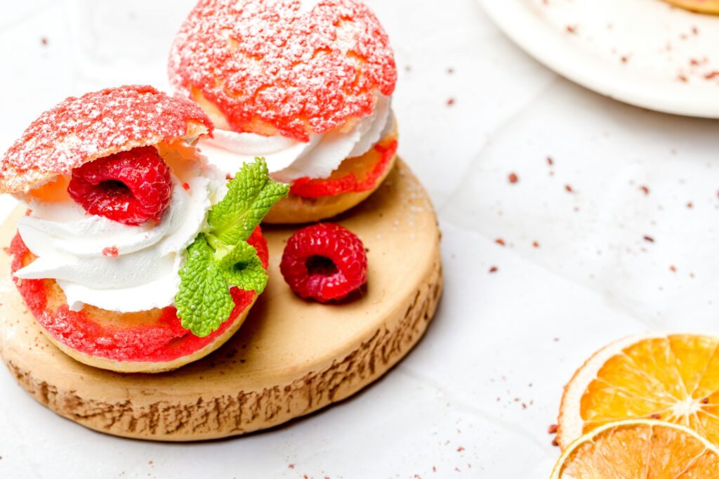 Shu cake. Custard dessert with creamy white cream, decorated with raspberries